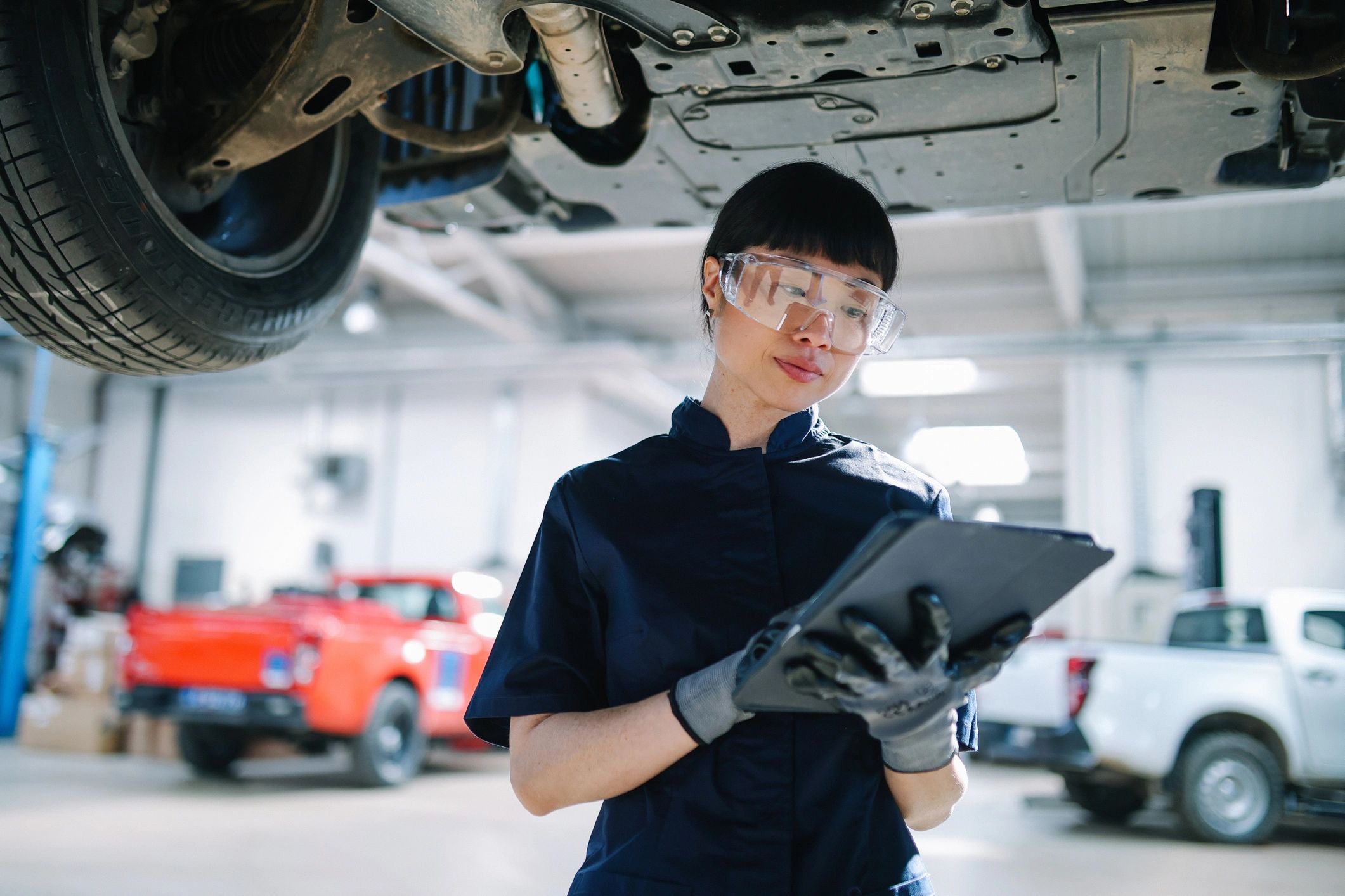 Technician inspecting a vehicle in a modern auto repair shop